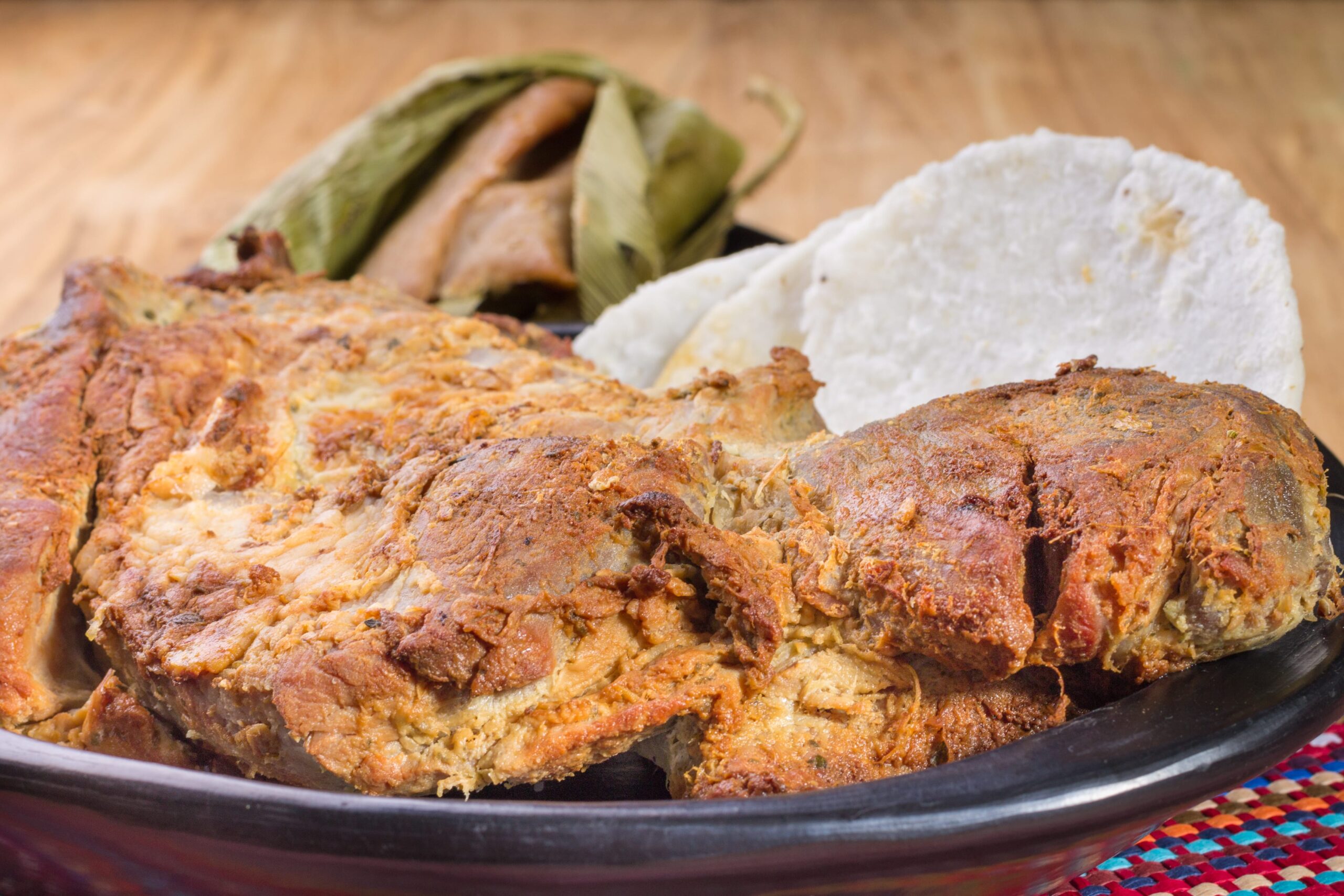 Plato de asado huilense, con carne asada acompañada de yuca, plátano y hogao, destacando los sabores tradicionales de la gastronomía huilense